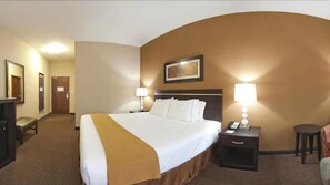 Une chambre d’hôtel avec un grand lit, deux tables de chevet avec des lampes, un bureau et une chaise.