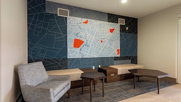 Un espace d’attente moderne doté d’une grande carte murale, de sièges et d’une petite table.