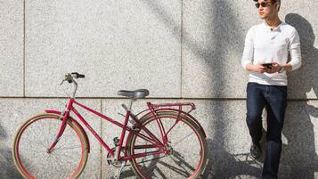Uma bicicleta vermelha encostada em uma parede texturizada.