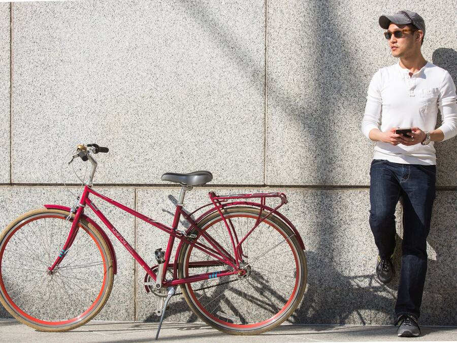 Uma bicicleta vermelha encostada em uma parede texturizada.