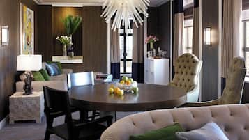 A dining area with a round table, chairs, and a chandelier.