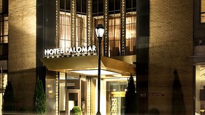 Entrada de um hotel com uma placa grande que diz "HOTEL PALOMAR".