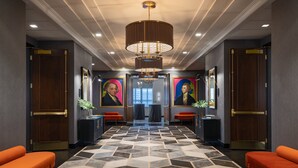 A hallway with a patterned floor, two red sofas, and a chandelier. - Kimpton Hotel Palomar Philadelphia by IHG (Philadelphia)