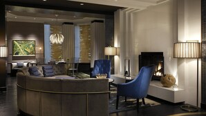 A modern lounge area with a curved sofa, blue armchairs, and a fireplace. - Kimpton Hotel Palomar Philadelphia by IHG (Philadelphia)