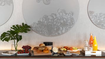 A breakfast buffet with various food items, a plant, and decorative wall panels.