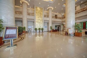A spacious lobby with high ceilings, large columns, and a grand staircase. - Petroleum Hotel (Jinzhou)