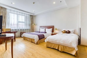 A hotel room with two beds, a desk, and a TV. - Petroleum Hotel (Jinzhou)