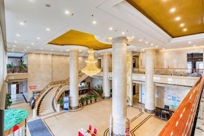 A spacious lobby with high ceilings, large columns, a grand chandelier, and a central staircase. - Petroleum Hotel (Jinzhou)