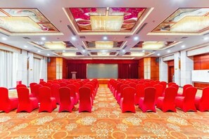 A conference room with rows of chairs, a stage, and a large screen. - Petroleum Hotel (Jinzhou)