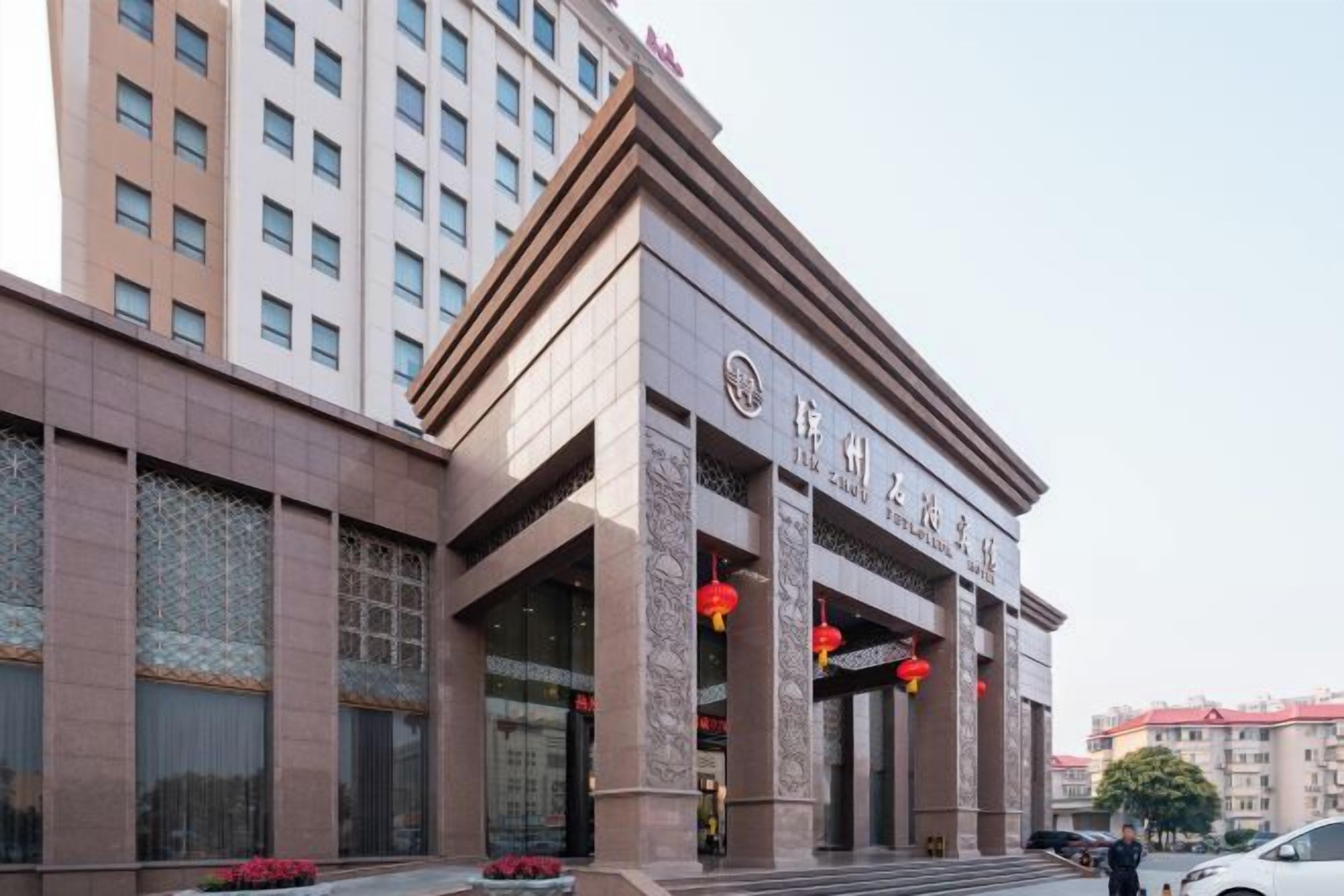 A hotel with a traditional architectural style, featuring a prominent entrance with large columns and a sign above the doors.