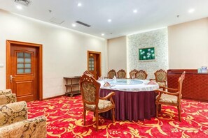 A conference room with a round table, chairs, and a carpeted floor. - Petroleum Hotel (Jinzhou)