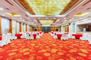 A large conference room with rows of tables and chairs, a red carpet, and a chandelier. - Petroleum Hotel (Jinzhou)