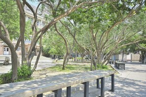 A park bench, trees, and a building in the background.