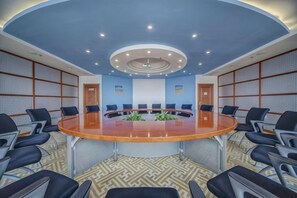 A conference room with a round table, multiple chairs, and a patterned carpet. - Petroleum Hotel (Jinzhou)