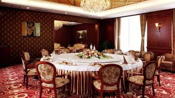 Un comedor formal con una mesa redonda, sillas y una araña.