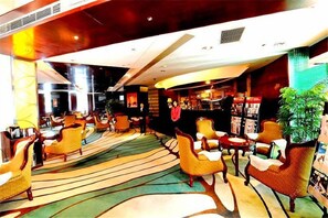 A hotel lobby with multiple seating areas, a bar, and a reception desk. - Huadu International Hotel (Xiangtan)
