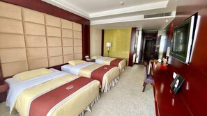 A hotel room with three beds, a TV, and a desk. - Huadu International Hotel (Xiangtan)