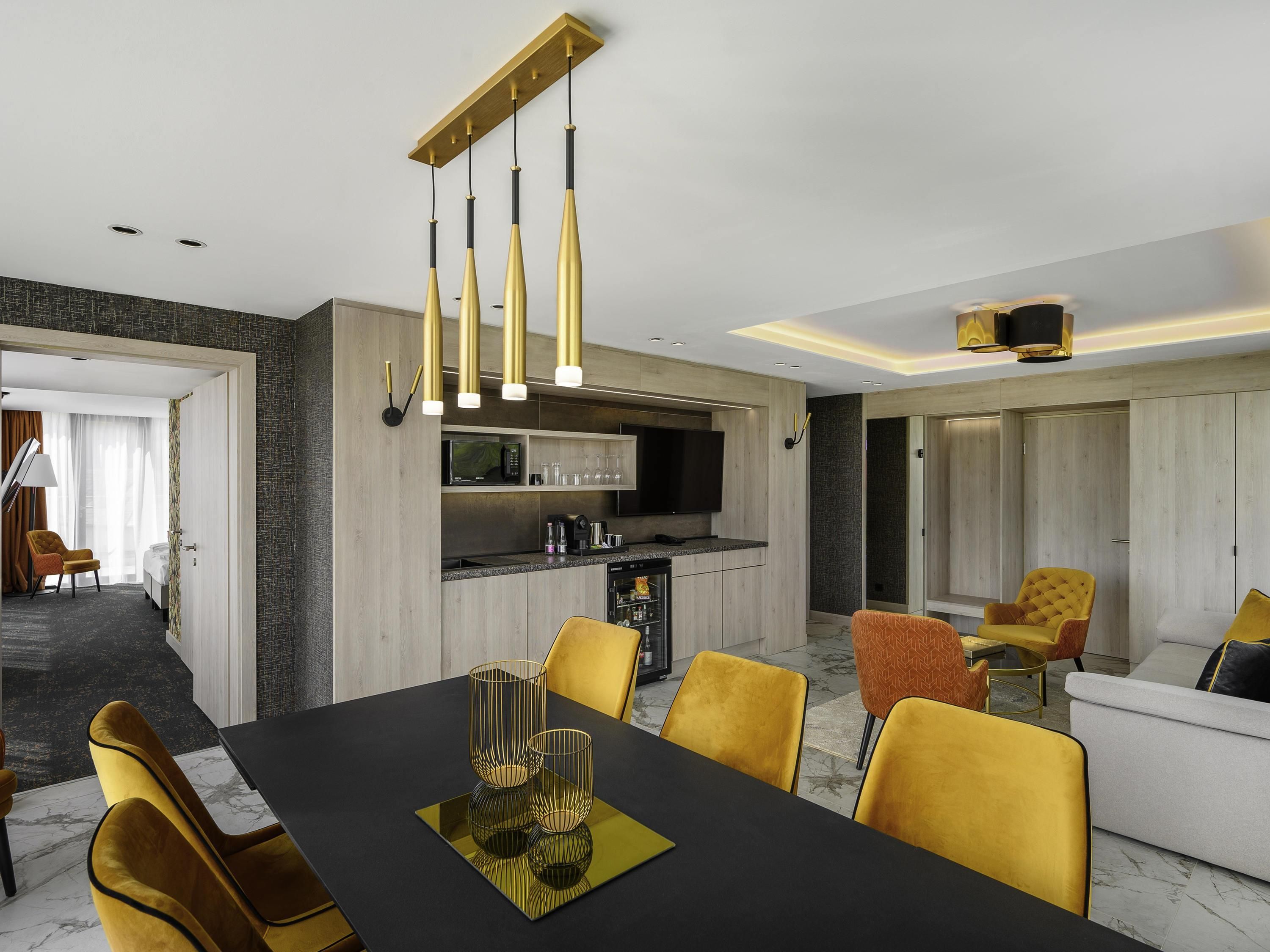 Una habitación de hotel moderna con comedor, cocina y sala de estar.