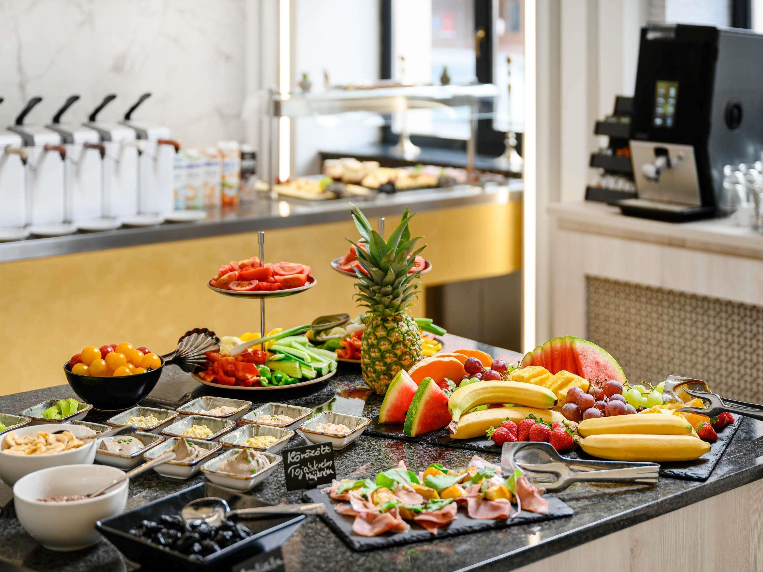A buffet with various food items and a coffee machine.