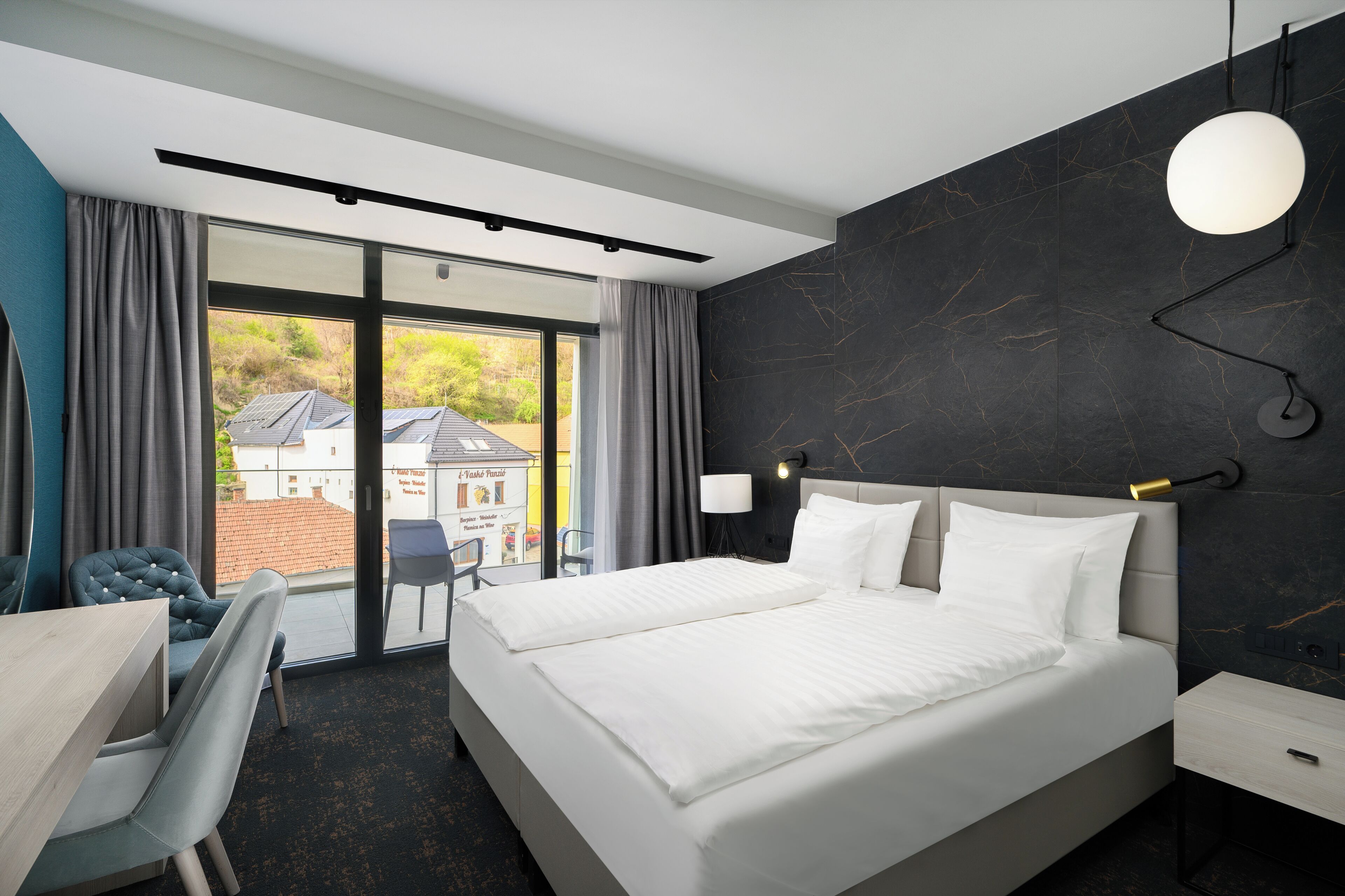 Habitación de hotel moderna con una cama grande, un escritorio y vistas al exterior.