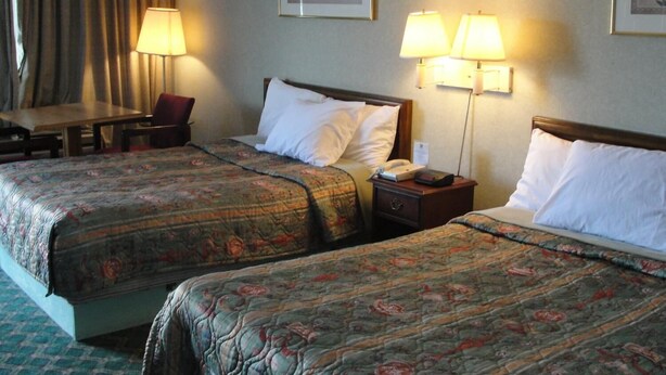 Habitació d'hotel amb dos llits, un escriptori i dues làmpades.