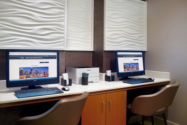 A modern office setup with two monitors, a desktop computer, and a printer.