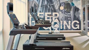 Un gimnasio con cintas de correr, sistema FlexDeck de absorción de impactos y un cartel motivacional.