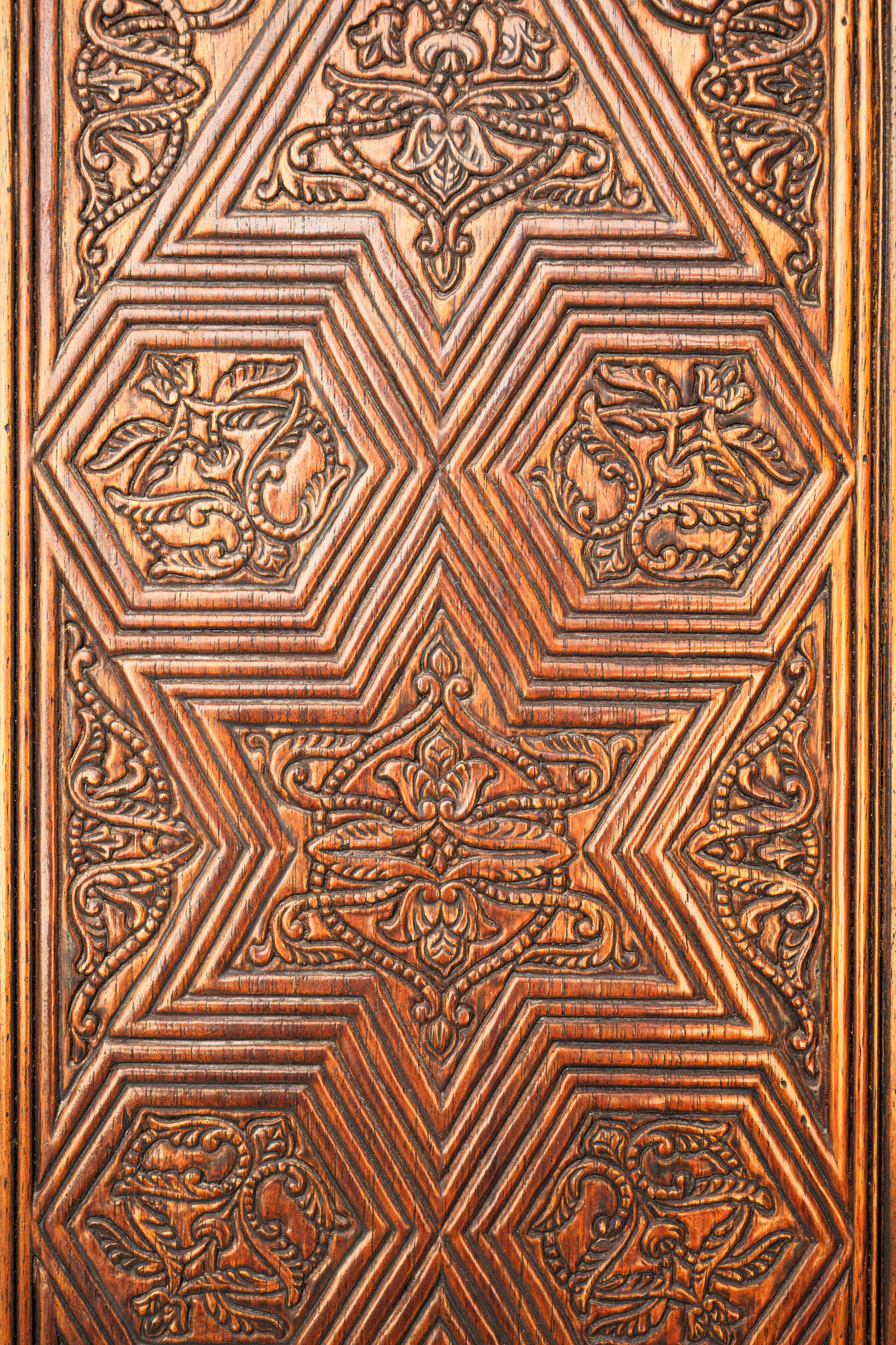 Un panel de madera tallada con detalle, con motivos geométricos y florales.
