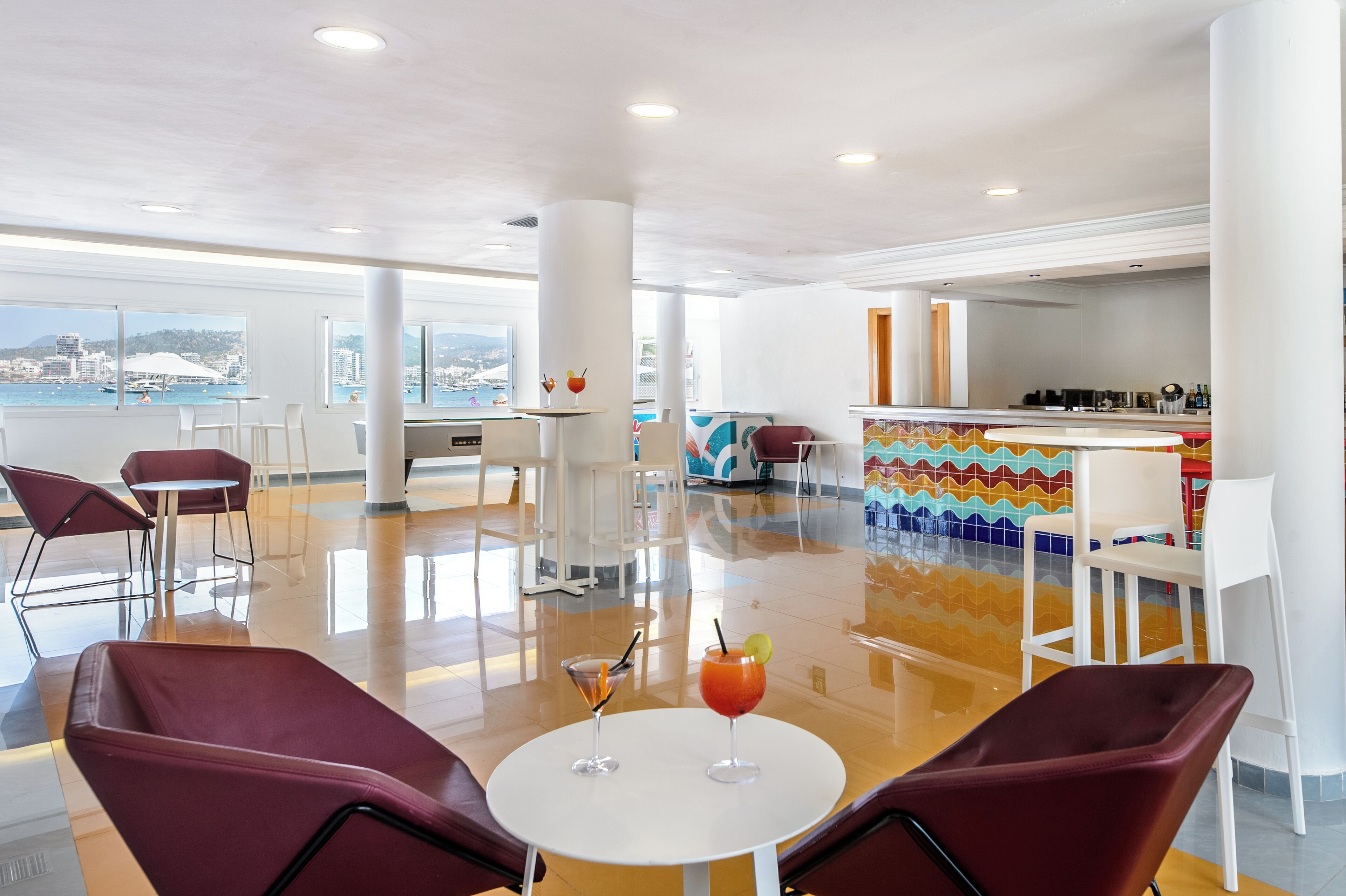 A modern lounge area with a pool table, bar, and seating.
