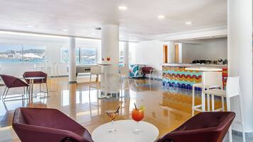 A modern lounge area with a pool table, bar, and seating.