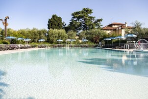 Una piscina al aire libre de temporada, sombrillas