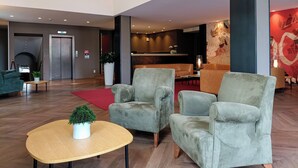 Un vestíbul modern amb butaques confortables, una taula d'informació i una llar de foc.