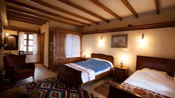 A traditional room with a wooden bed, a chair, a patterned rug, and a wooden ceiling.