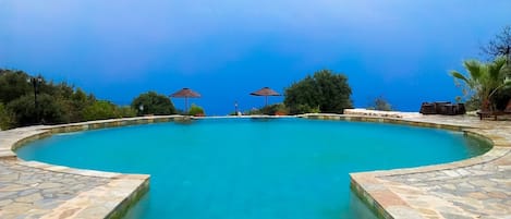 Piscine extérieure, parasols de plage, chaises longues