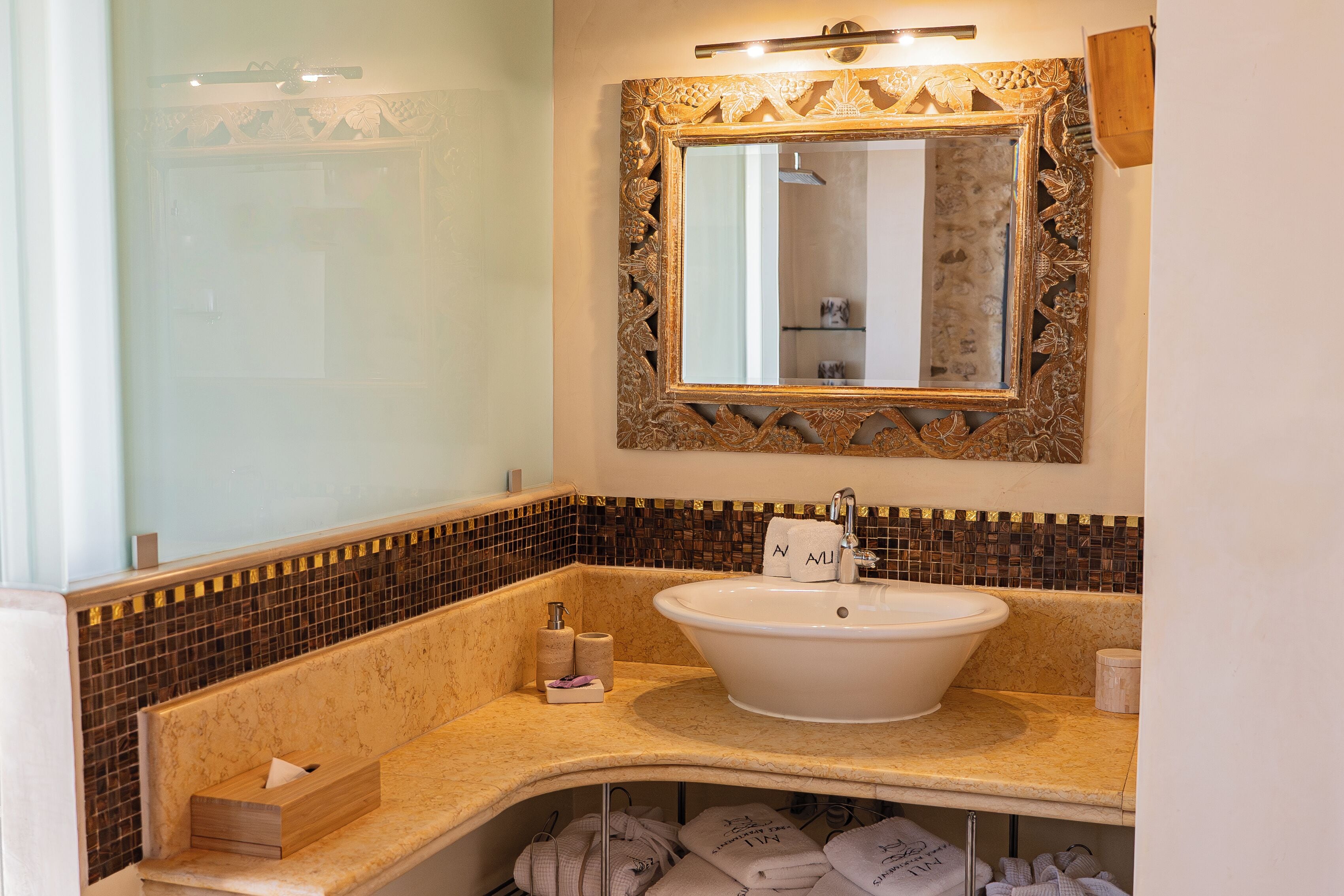 Ein Badezimmer mit freistehender Badewanne, einem Spiegel mit aufwendiger Riegelung und einer Fliesenküchenzeile.