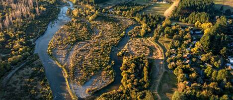 An aerial view of a rural landscape with a river, fields, and scattered houses.