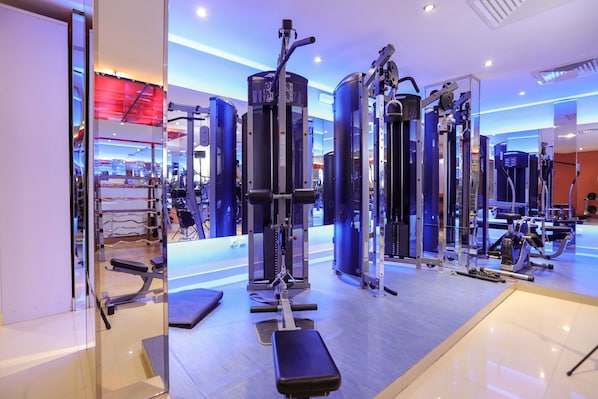 A modern gym with various exercise machines, a bench, and a mirrored wall. - LE DIYAR Al Waha Hotel Riyadh (Riyadh)