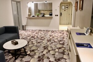A modern living room with a sofa, a coffee table, and a patterned floor.