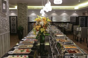 A buffet setup with various food items and a central floral arrangement.