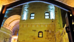 The entrance of the Perimassari Hotel with stone walls, a central archway, and a staircase leading up to the entrance. - Perimasali Cave Hotel - Cappadocia (Ürgüp)