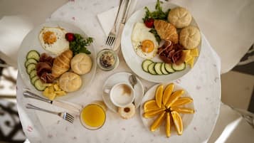 Duas travessas de comida com pães, ovos, queijo e legumes sobre uma mesa.