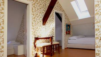 A bedroom with a bunk bed, a wooden bench, and a skylight.