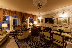 Uma sala de estar bem equipada com sofá, poltronas, mesa de centro e televisão.