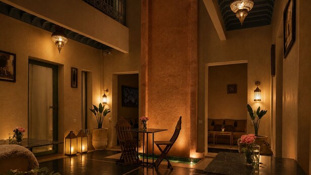 A spacious indoor area with a high ceiling, a dining table with chairs, and a seating area with a sofa. - Riad Dar More (Marrakech)