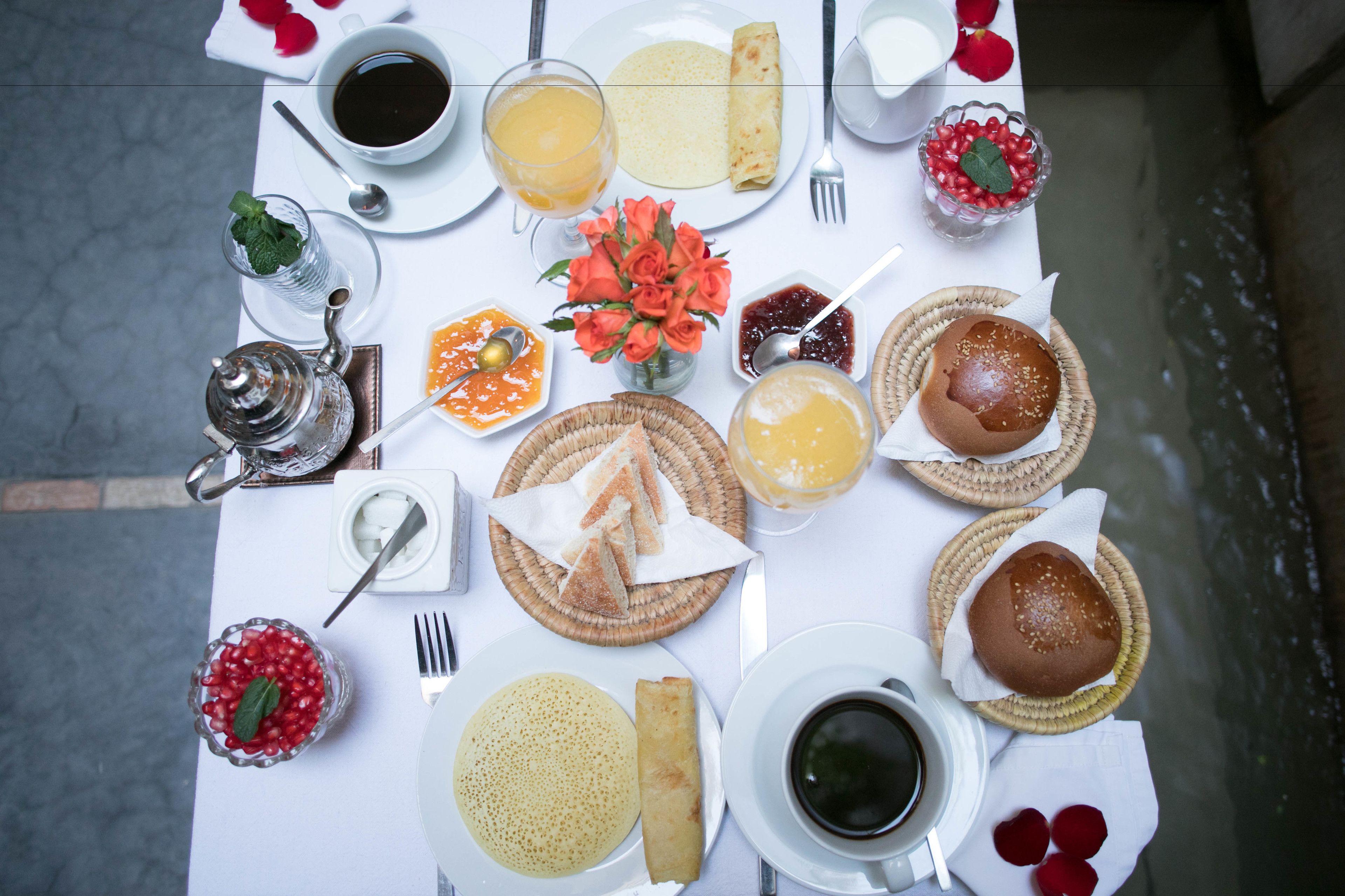 A table set with various breakfast items including bread, pastries, and beverages.