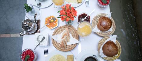 A table set with various breakfast items including bread, pastries, and beverages.