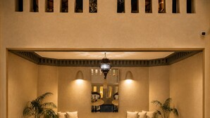 A spacious interior with a balcony, a chandelier, and potted plants. - Riad Dar More (Marrakech)