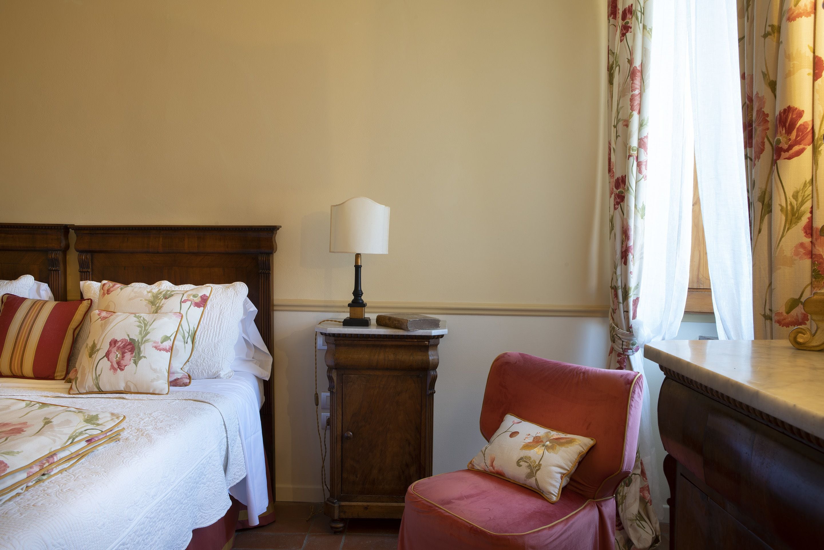 Une chambre à coucher avec un lit, une table de chevet, une chaise et une lampe.