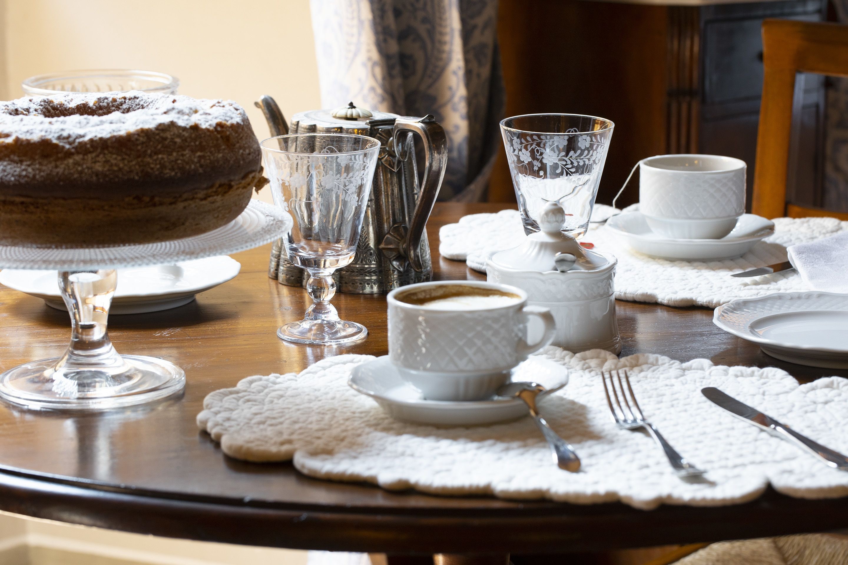 Ein Tisch, gedeckt mit Kuchen, Kaffeetassen und einer Zuckerdose.