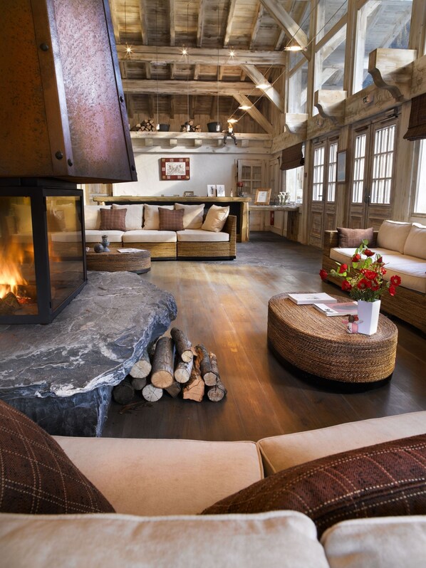 A cozy living room with a fireplace, wooden furniture, and a stone accent.